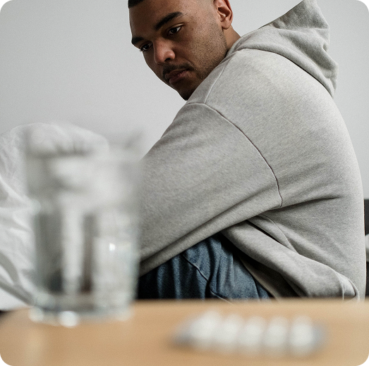 Patient sitting with antidepressant pills in the foreground, representing frustration after multiple medications.