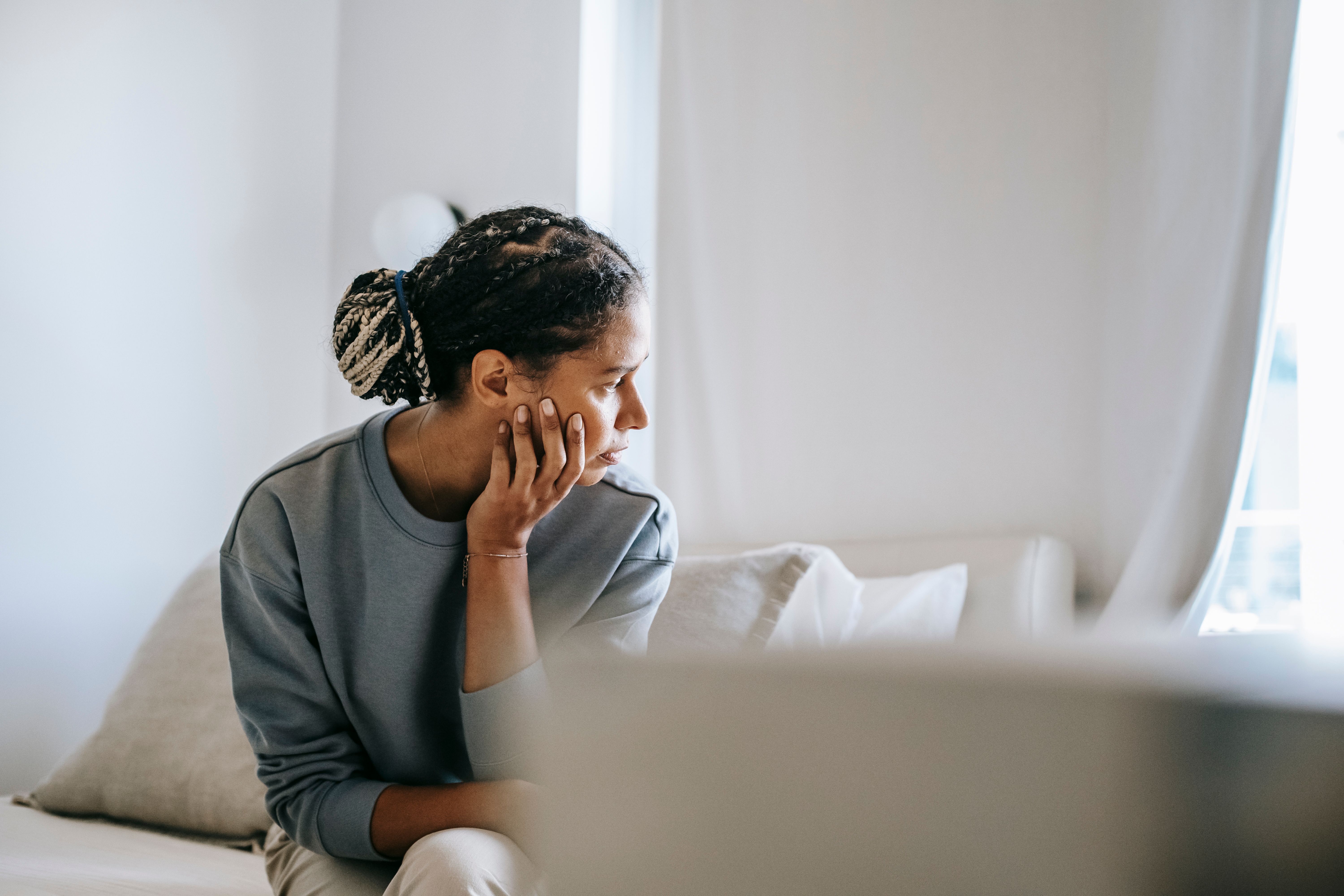 Patient closing her eyes in a warm room, representing brain fog and mental fatigue.