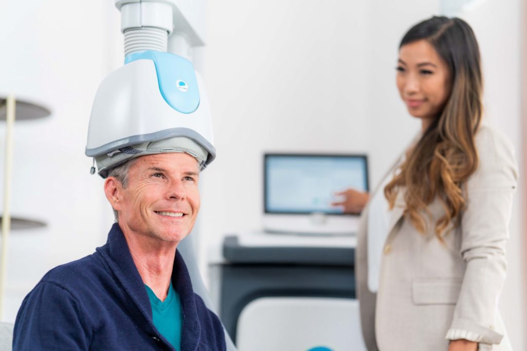 A patient receiving a TMS session while remaining awake and comfortable.